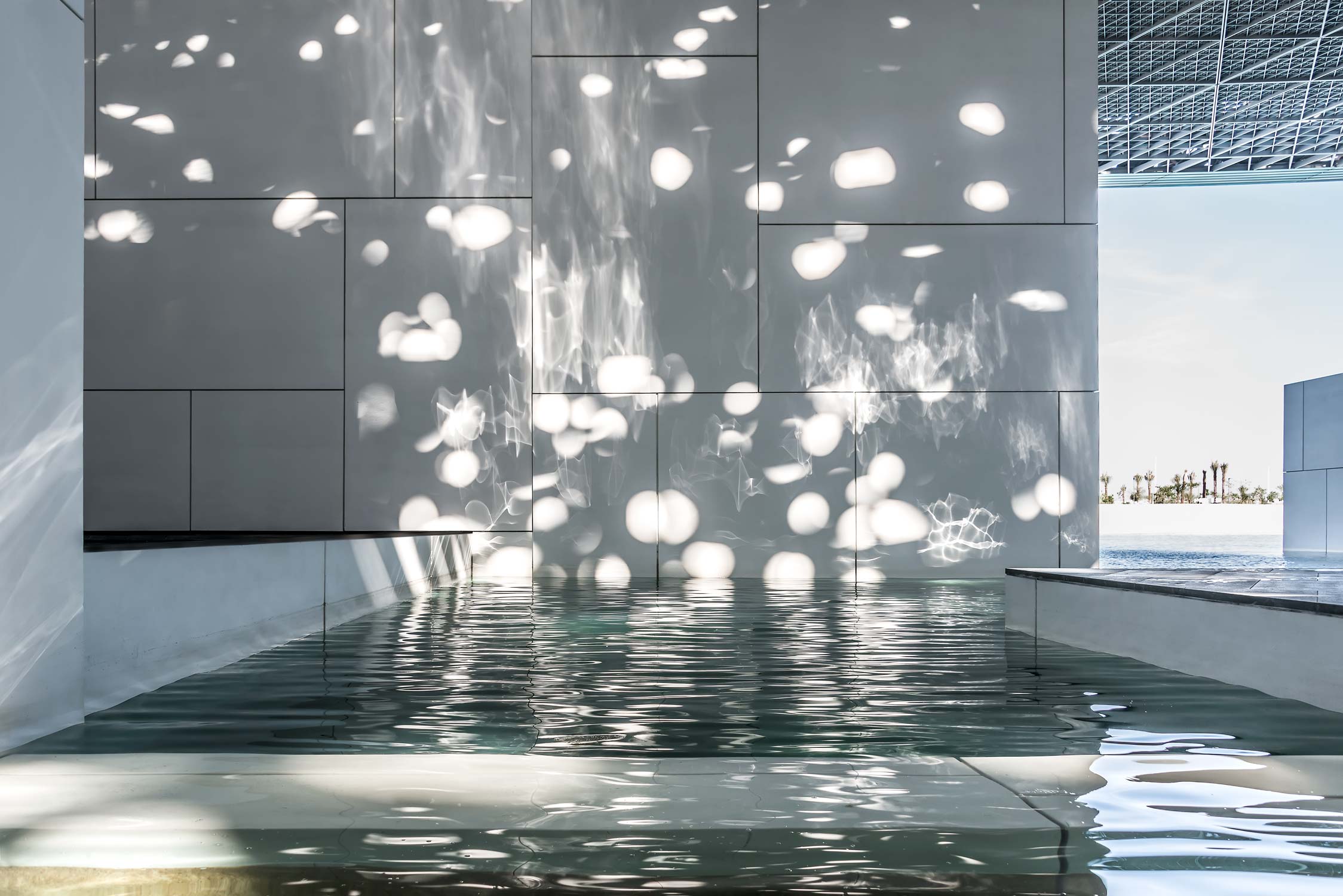 Detail von einem Wasserbassin im Kunstmuseum Louvre von Jean Nouvel in Abu-Dhabi. Das Kuppeldach lässt Lichtstrahlen eindringen, wie einen Lichtregen.