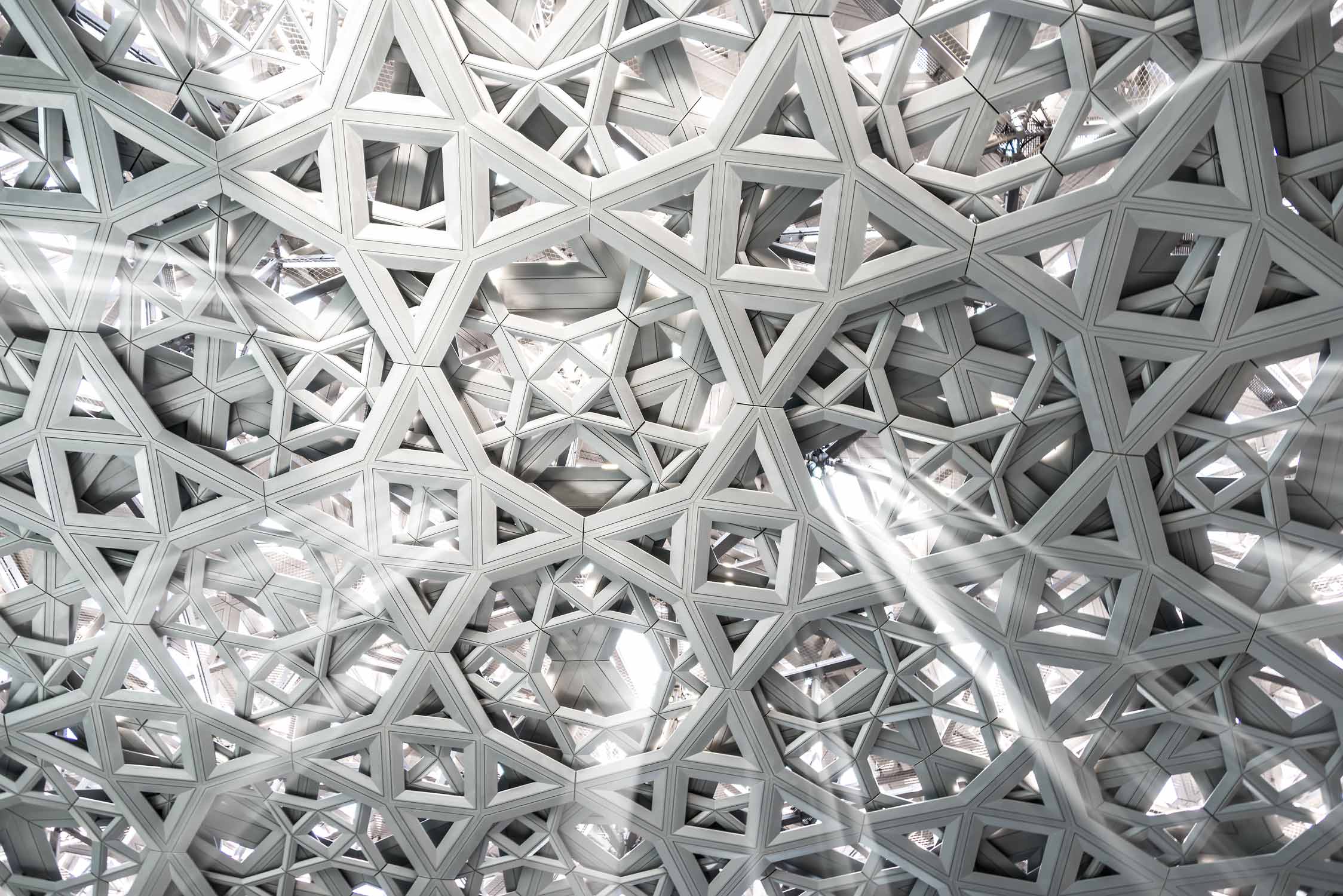 Detail vom Kuppeldach im Kunstmuseum Louvre von Jean Nouvel in Abu-Dhabi. Das Kuppeldach lässt Lichtstrahlen eindringen, wie einen Lichtregen.