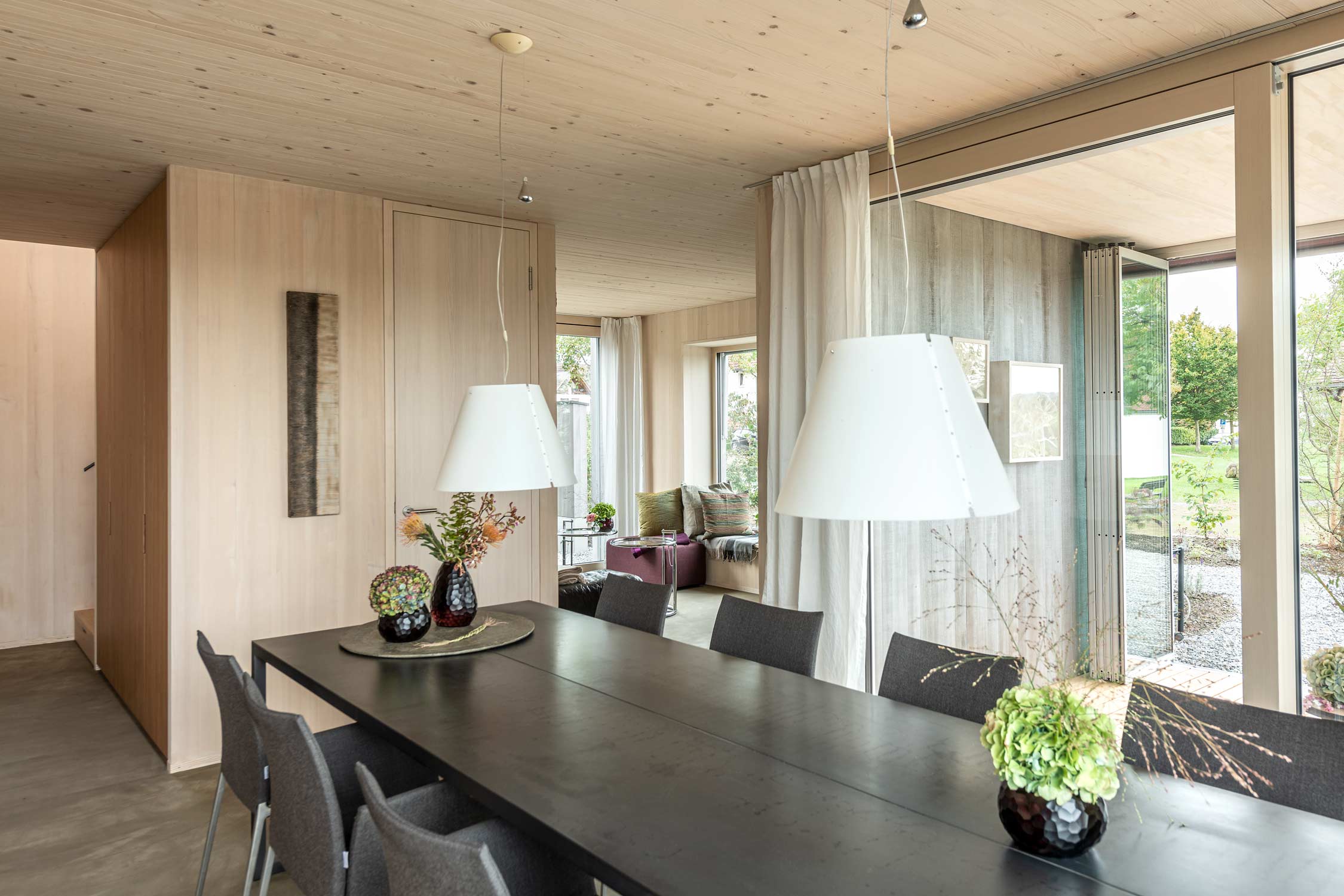 Wohn-Essbereich im Zwei Generationenhaus mit viel Holz. Fotografiert von Regine Giesecke Architecture Photography GmbH