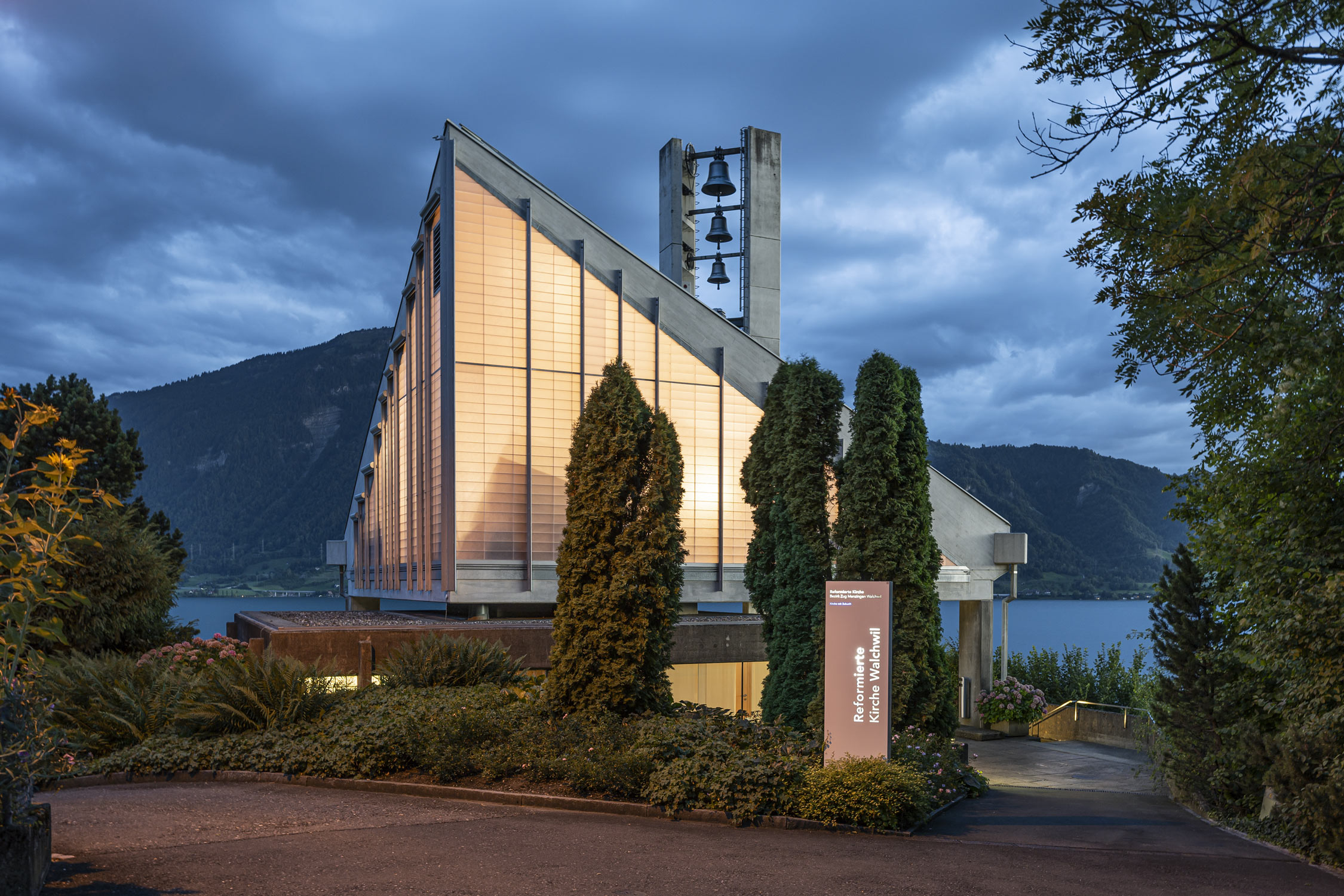 illuminierte Reformierte Kirche Walchwil in der Abenddaemmerung Architektrufotograf Regine Giesecke
